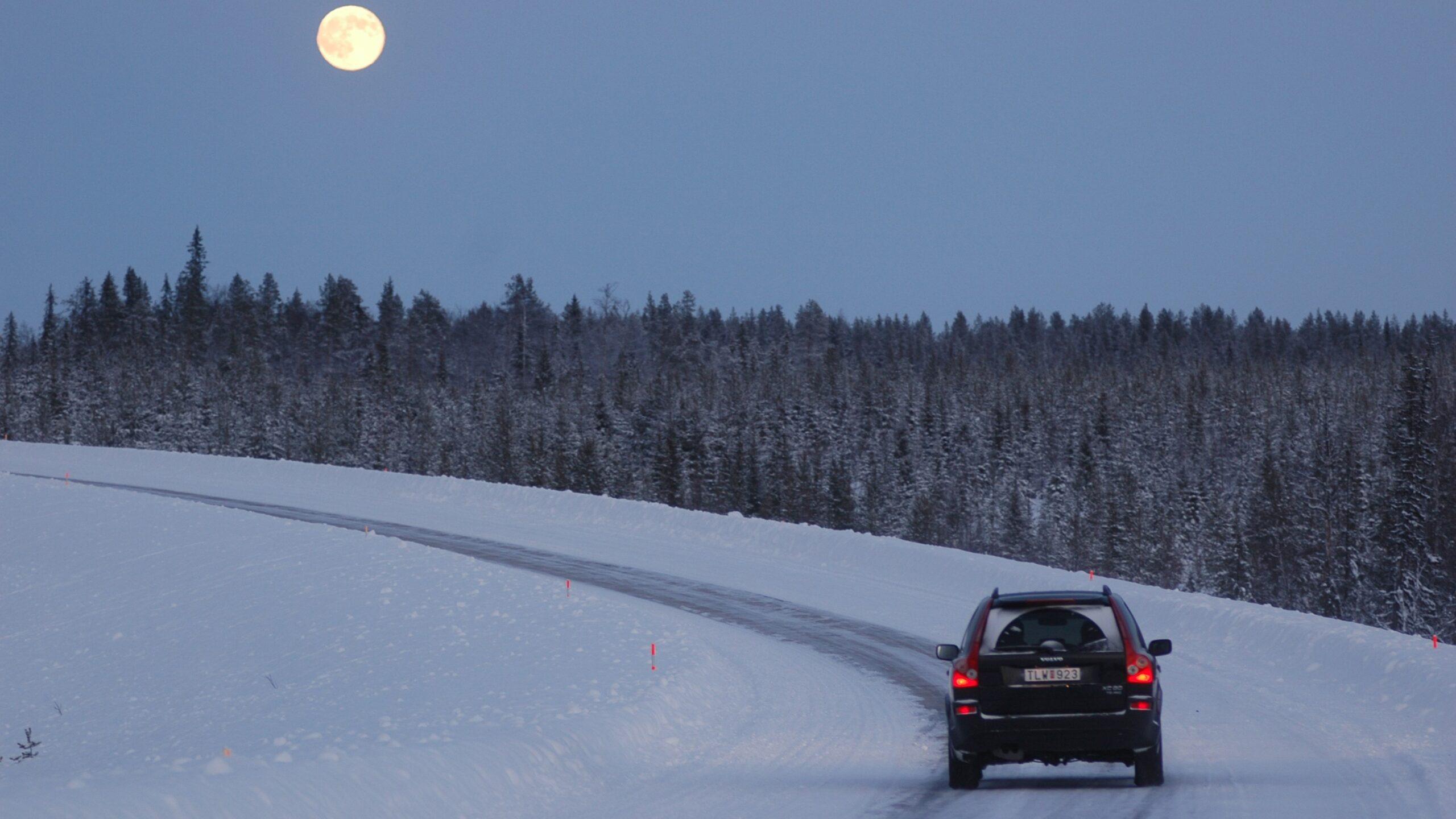 Vehículo circulando sobre una carretera cubierta de nieve.