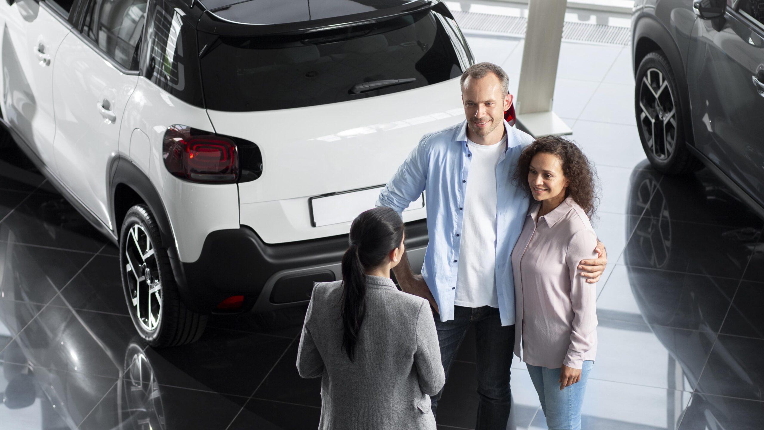 Pareja buscando coche nuevo en un concesionario.