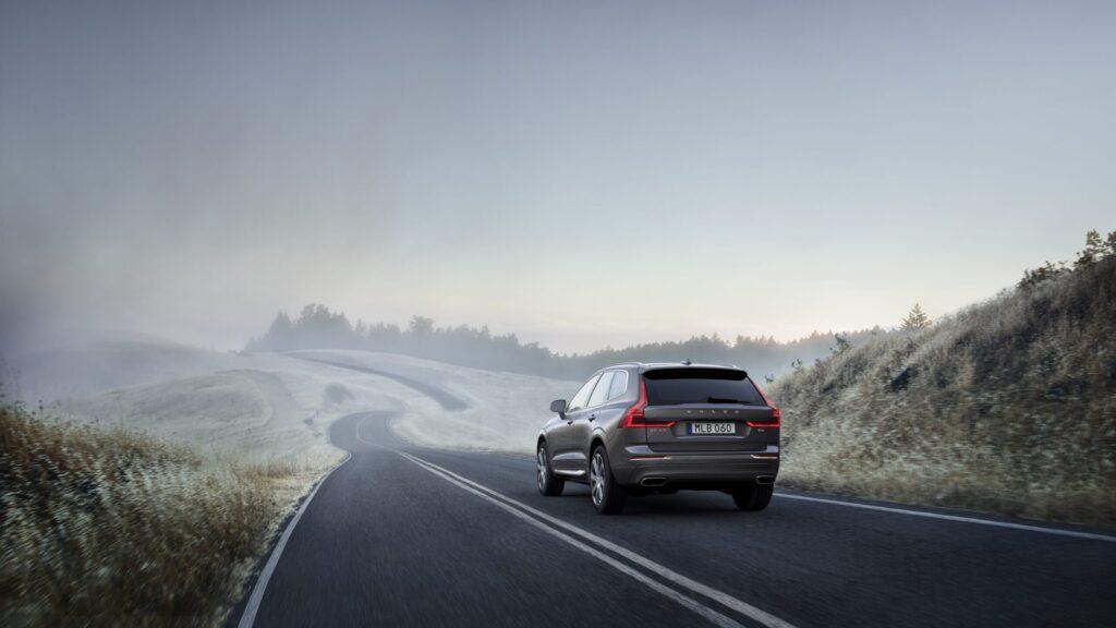 Un vehículo Volvo circulaba por una carretera cubierta de bruma o niebla.